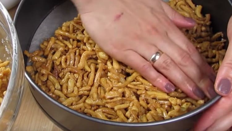 We take a detachable baking dish, cover it with parchment and tamp the chuck chuck.