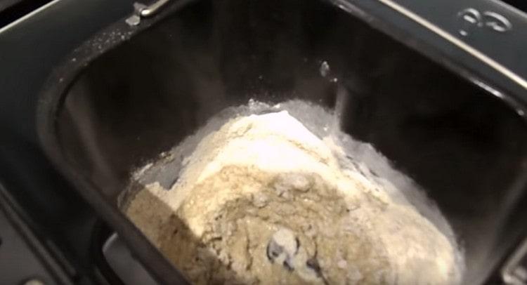 In the bucket of the bread machine we spread the leaven, add a little rye flour and water.