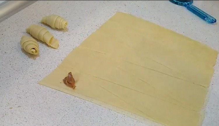 On the wide side of the triangle of dough we spread the filling of boiled condensed milk.