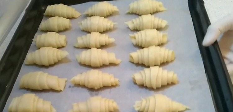 The resulting bagels are laid out on a baking sheet covered with parchment.
