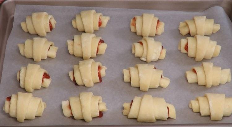 We spread the bagels from the cottage cheese for the baking sheet covered with parchment and send it to the oven.