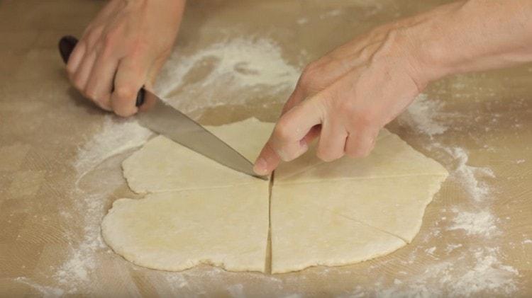 Having cut off half of the dough, we roll this piece into a circle, which we cut into triangles.