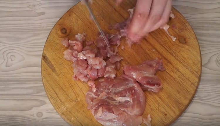 Cut meat with fat from chicken thighs.