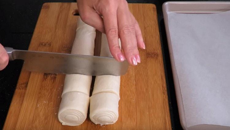 Cut the dough rolls into portioned slices.