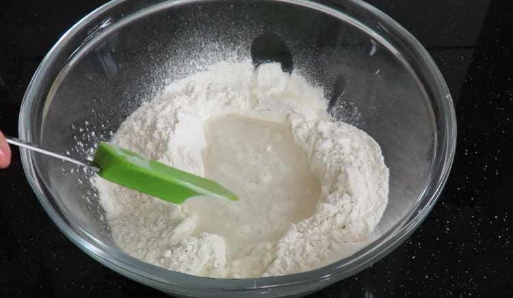 We add water and salt to the flour, making a depression in it.