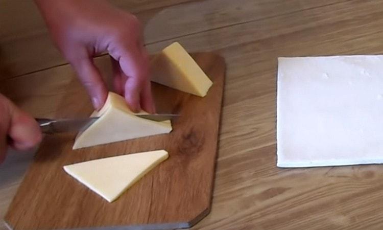 Cut cheese into triangles.
