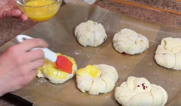 Grease our puffs with a beaten egg.