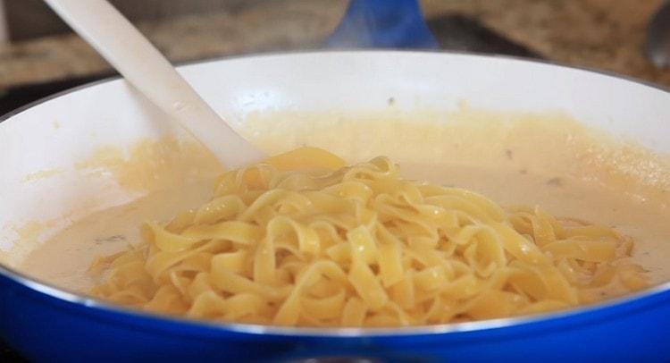 We transfer the finished spaghetti to the pan in the sauce.
