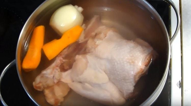 We spread the chicken meat, onion and carrot in a pan, pour water.