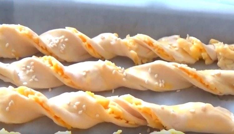 Sprinkle sticks with sesame seeds.