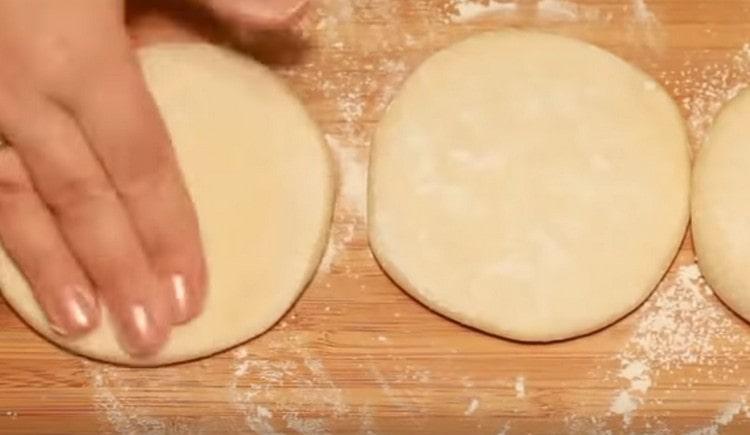 Having sprinkled the table with flour and starch, we spread three flat cakes on it.
