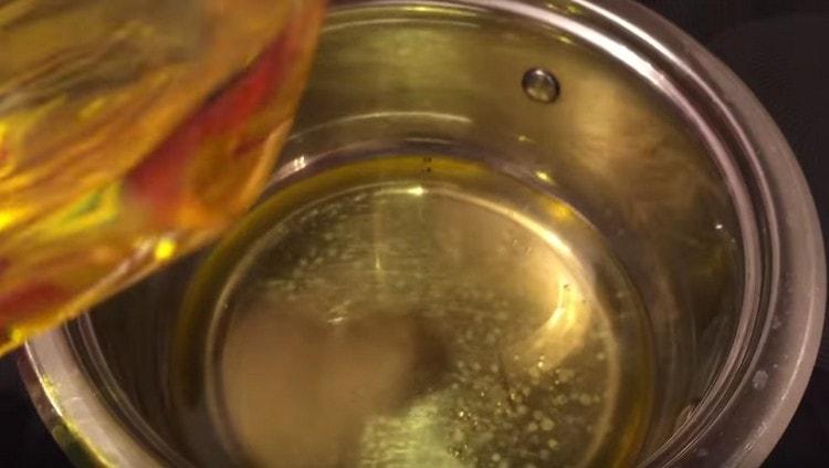 Preheat vegetable oil in a saucepan.