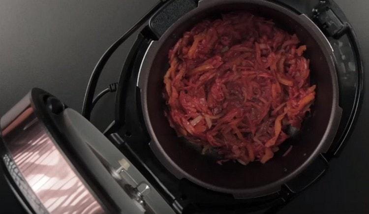 In the multicooker bowl, put all the chopped vegetables and add the tomato paste.