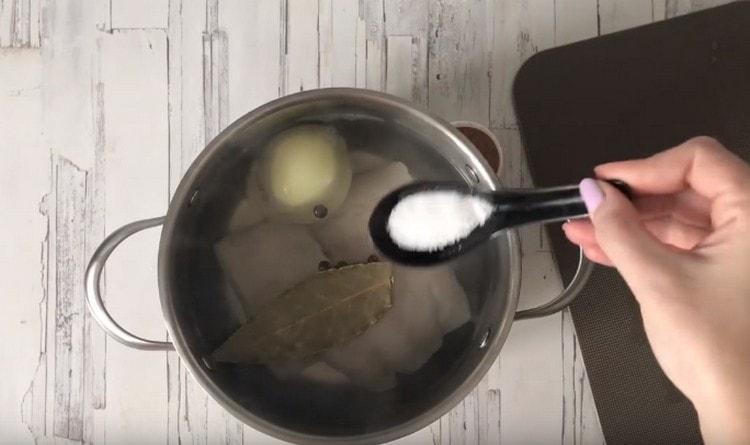 In the pan we spread the fish, onions, celery, pepper in a pot, bay leaf, add salt.