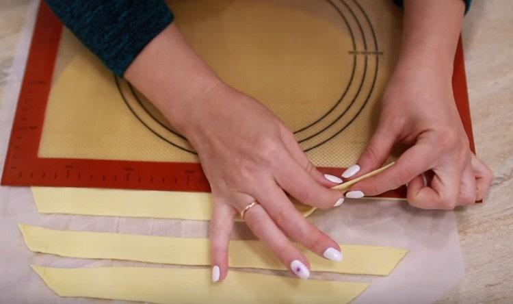 Roll the puff pastry thinly and cut into thin long strips.
