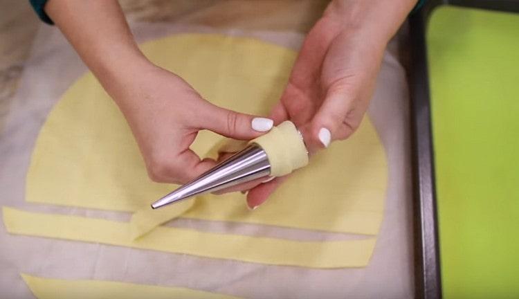 We wind the dough with an overlap on the molds.