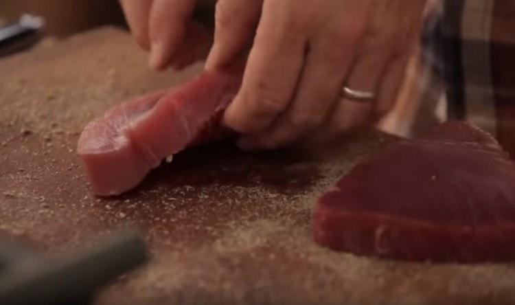 Pour the chopped spices onto the board and roll steaks in them.