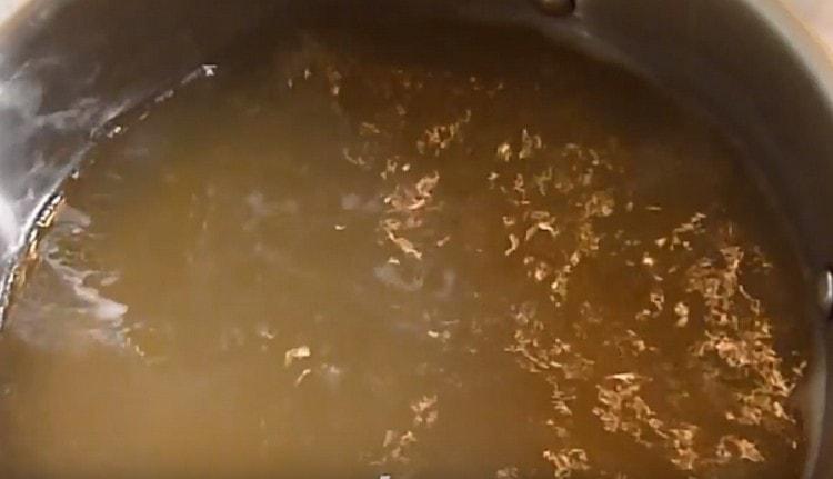 After filtering the broth, we return it to the stove.