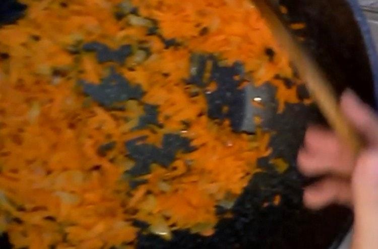 Strain onions with carrots in a pan.