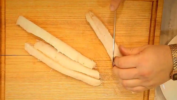 Cod fillet cut into long strips, each of which is cut in half obliquely.