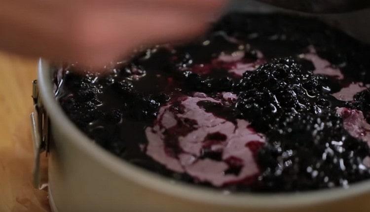 Align the blueberry jelly on the surface of the future cheesecake and send the dessert to the refrigerator.