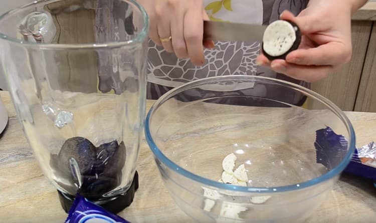 We divide Oreo cookies, scrape the cream from it with a knife into a bowl.