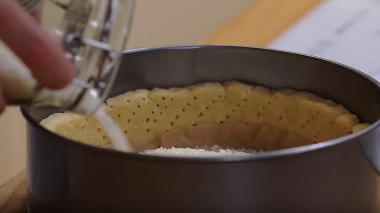 Covering the bottom of the base with parchment, pour a load, for example, rice.
