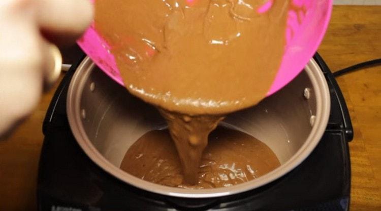 Lubricate the multicooker bowl with a piece of butter and pour the dough into it.