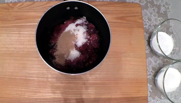 We spread cherries in a stewpan, add sugar and cinnamon to them.