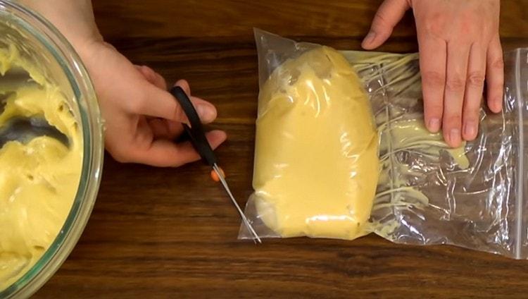 We shift the dough into a bag and cut off the corners of it.