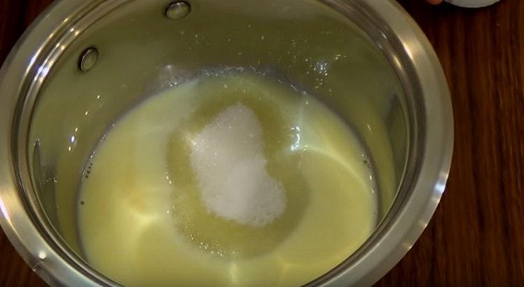 Add sugar and vanilla sugar to the mixture of milk and yolk.