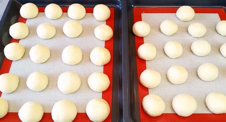 To prepare cheesecakes with cottage cheese, put the dough on a baking tray