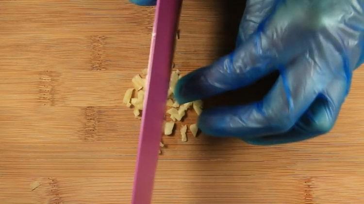 To cook salmon in a creamy sauce, chop the garlic