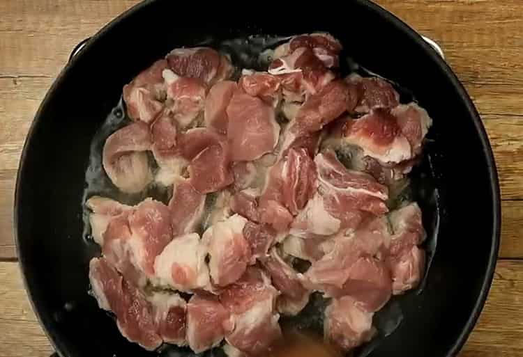 Cooking pasta with meat in a pan