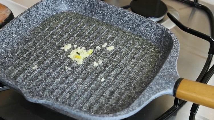 To make salmon steak, fry the garlic in a skillet