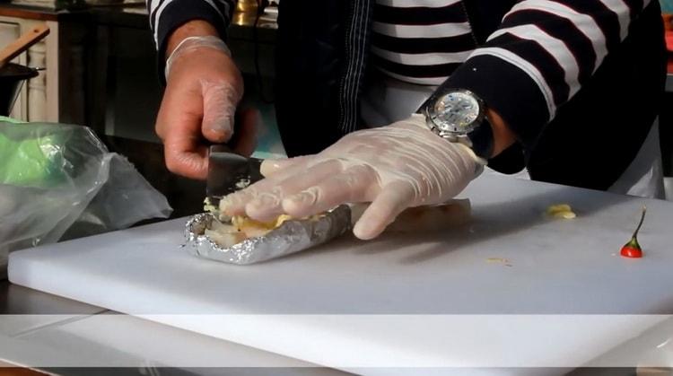 To prepare cod in foil in the oven, rub the garlic