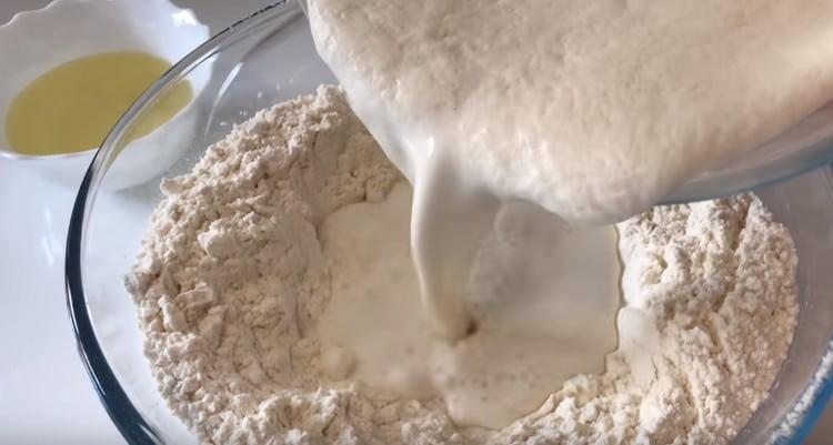 Pour dough into the groove in the flour.