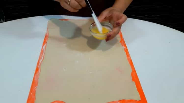 To make puff pastry strudel, grease the dough