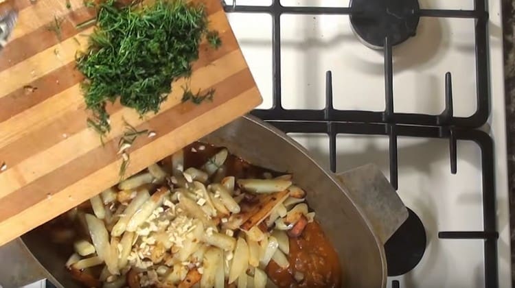 We send the potatoes to the cauldron for meat, add chopped garlic and herbs.