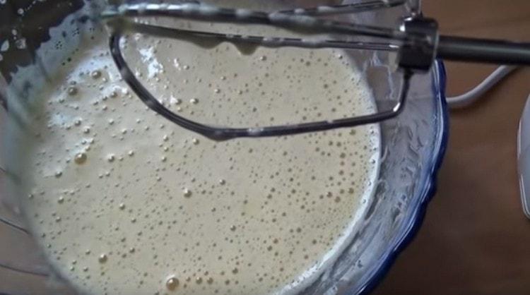 Beat eggs with sugar using a mixer.