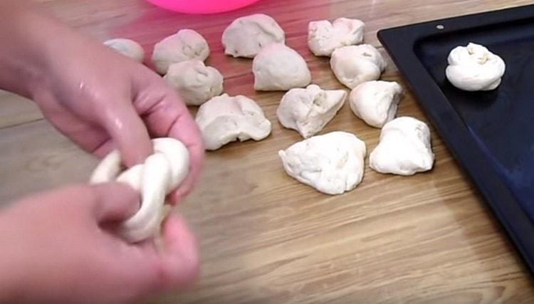 We roll a sausage from each piece of dough, and we knot it.