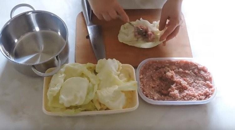 Put the minced meat on the cabbage leaves.