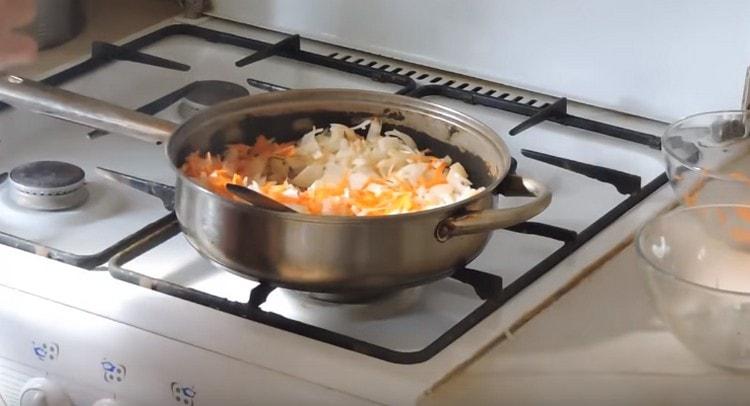 We pass the carrots with onions in a pan.