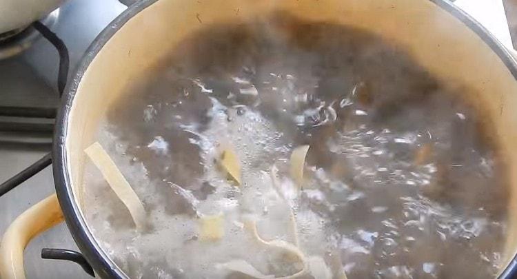 Add noodles to the pan with mushrooms and potatoes, then fry.