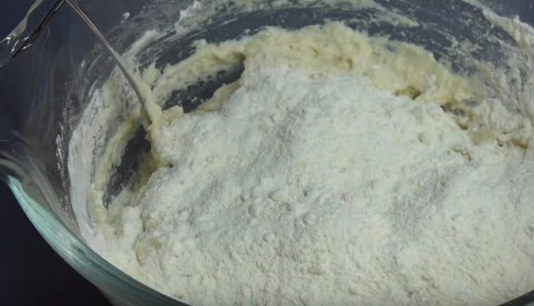 Add more flour and begin to knead the dough.