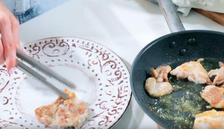 We shift the fried chicken on a plate, leave it to cool slightly.