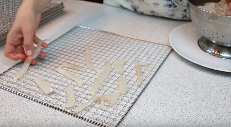 Carefully lay out the squid strips on the drying racks.