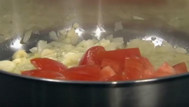Add the sliced tomatoes to the onion.