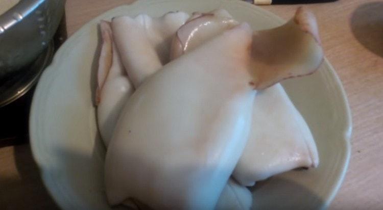 We keep squid for 2 minutes in boiling water, and then easily clean it from the film.