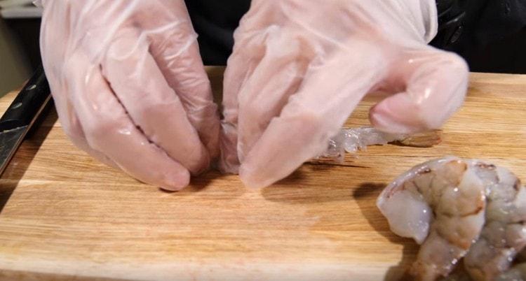 Hands pull the shrimp.